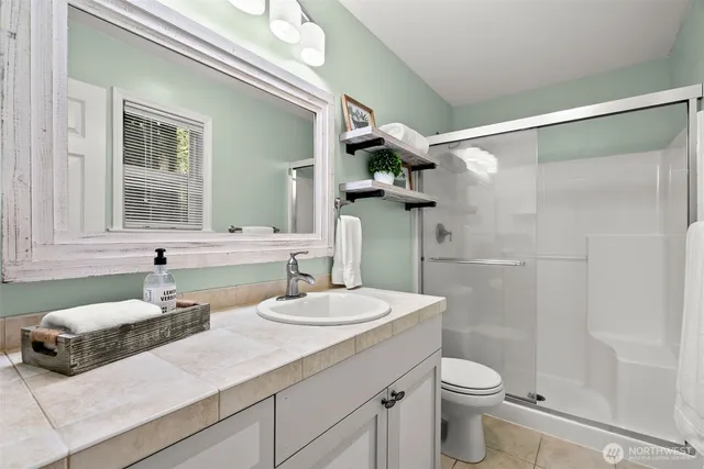 a bathroom with a sink and mirror with toilet
