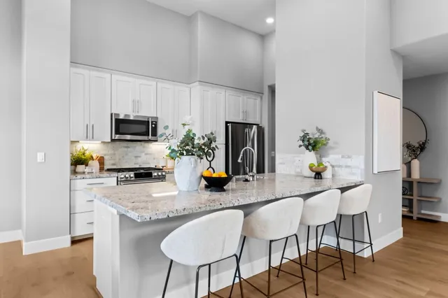a kitchen with granite countertop a sink dining table and chairs