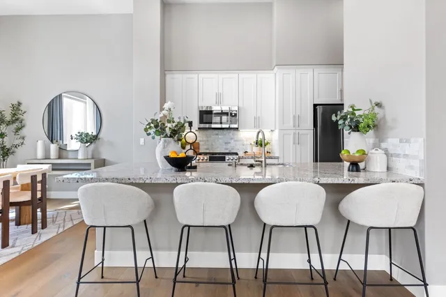 a kitchen with granite countertop a sink dining table and chairs