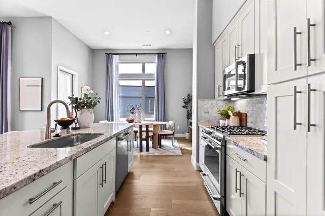 a dining room with furniture potted plants and wooden floor
