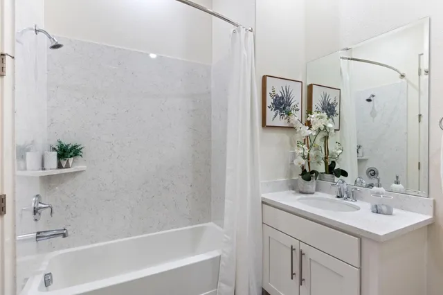 a bedroom with a bed a table and painting on the wall