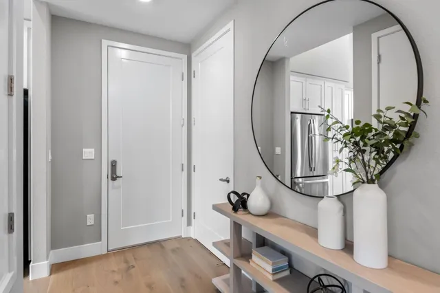 an entryway with wooden floor and a potted plant
