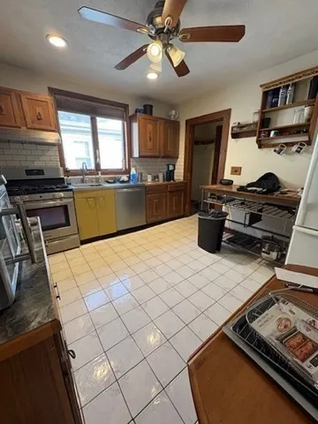 a kitchen with stainless steel appliances kitchen island granite countertop a sink stove and refrigerator