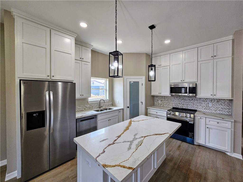 507 West Ragland Avenue Kingsville, TX 78363 - Photo 7 of 17 a kitchen with stainless steel appliances granite countertop a refrigerator a stove a sink a dining table and chairs