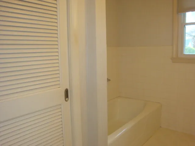 a bed in a bedroom next to a window