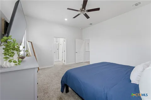 a spacious bedroom with a bed and a potted plant