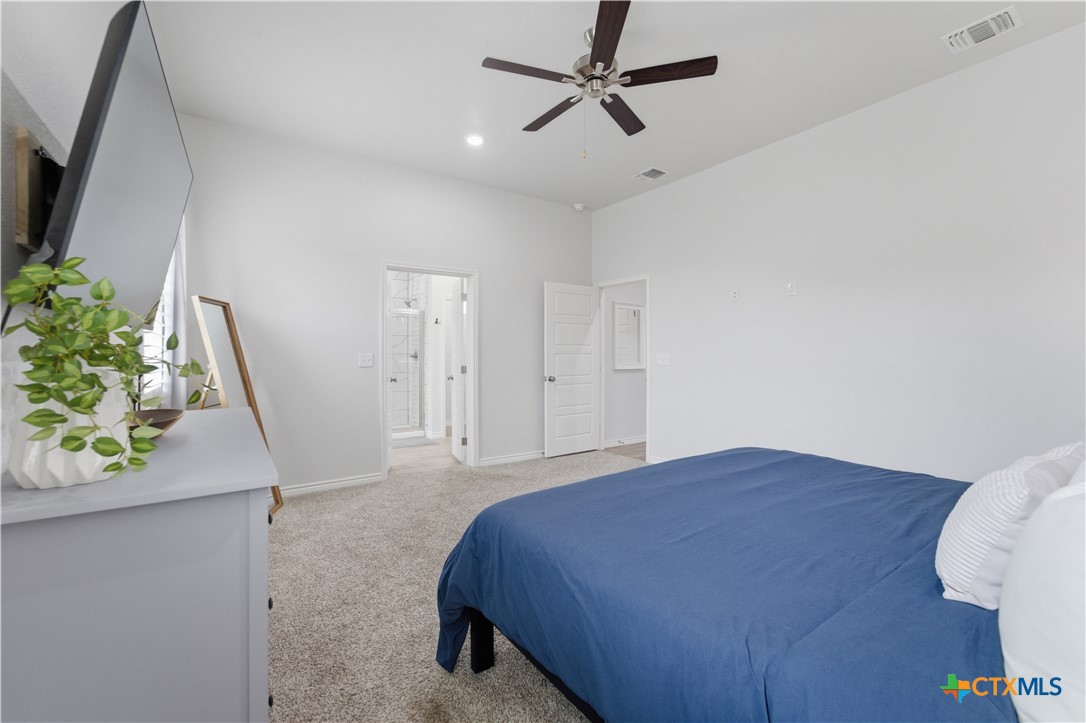 6003 Tivoli Road Temple, TX 76502 - Photo 14 of 30 a spacious bedroom with a bed and a potted plant