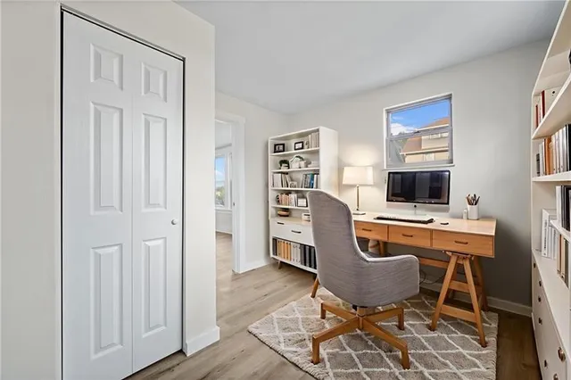 a view of a workspace with furniture and a window