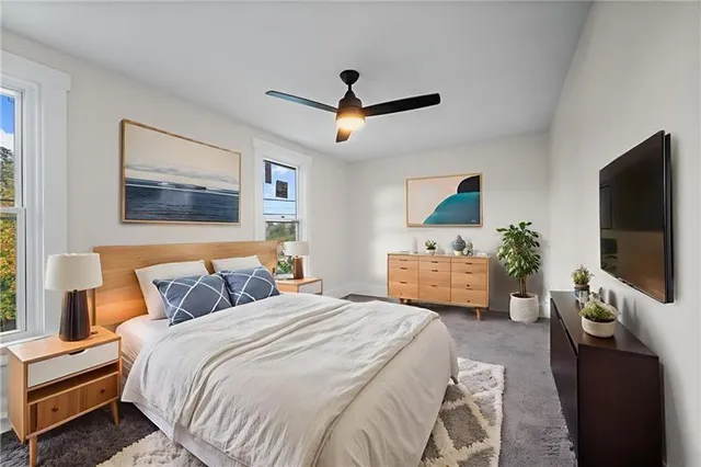 a bedroom with a bed a couch and a flat screen tv