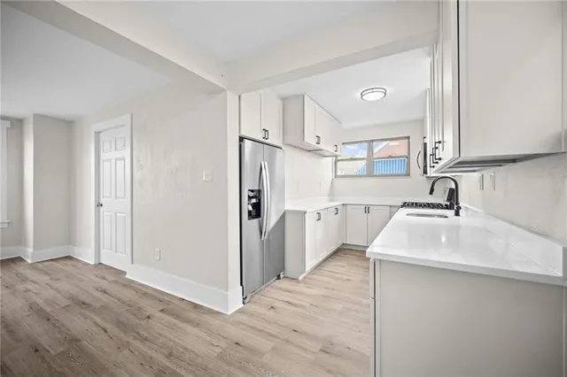 a kitchen with a sink cabinets stainless steel appliances and a window