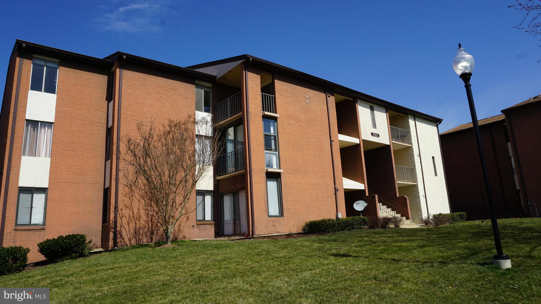 7923 Mandan Road, Unit 301 Greenbelt, MD 20770 - Photo 1 of 9 a front view of a house with a yard