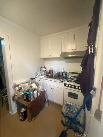 a kitchen with granite countertop a stove a sink and a refrigerator