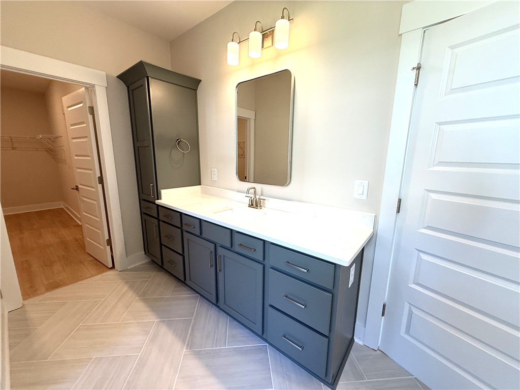 504 Tilman Court Anderson, SC 29621 - Photo 19 of 28 This bathroom features a sleek vanity and a spacious walk-in closet, blending comfort with convenience.