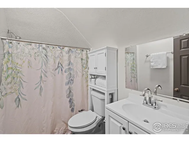 a bathroom with a sink toilet a mirror and shower curtain