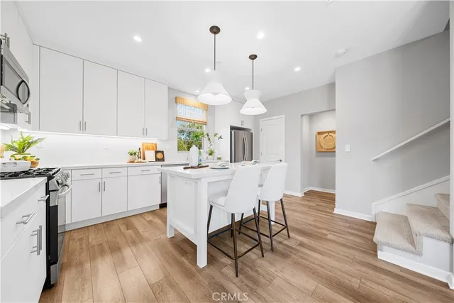 a kitchen with a sink a window stainless steel appliances and cabinets