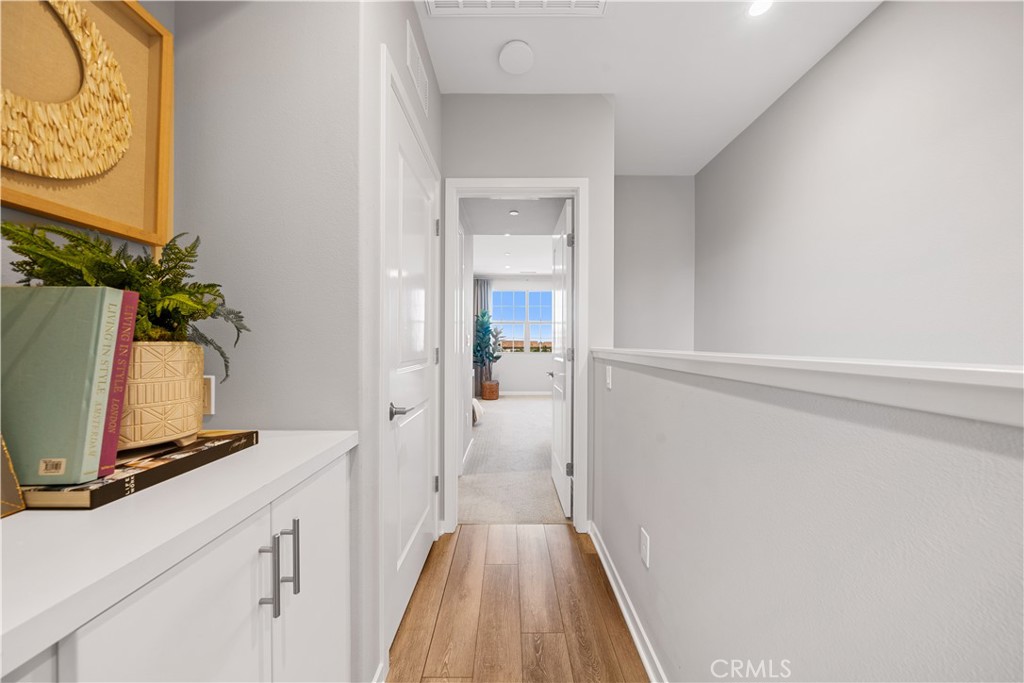 104 Coastal Garden Irvine, CA 92618 - Photo 21 of 43 a view of a hallway with wooden floor and a bathroom