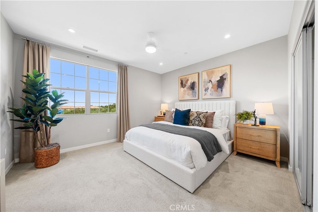 104 Coastal Garden Irvine, CA 92618 - Photo 22 of 43 a spacious bedroom with a bed and a potted plant