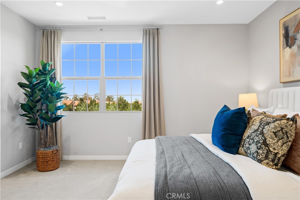 104 Coastal Garden Irvine, CA 92618 - Photo 23 of 43 a bedroom with a bed and a potted plant