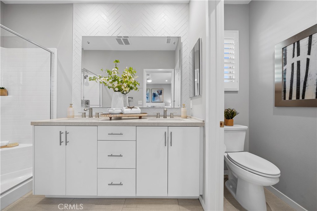104 Coastal Garden Irvine, CA 92618 - Photo 26 of 43 a bathroom with a granite countertop sink a toilet and a mirror