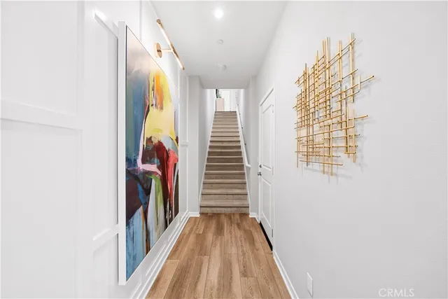 a view of a hallway with wooden floor and staircase