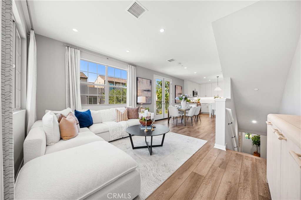 104 Coastal Garden Irvine, CA 92618 - Photo 6 of 43 a living room with furniture and a table with wooden floor