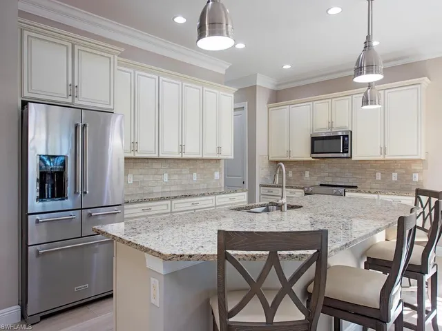 a kitchen with stainless steel appliances granite countertop a stove a refrigerator and a microwave