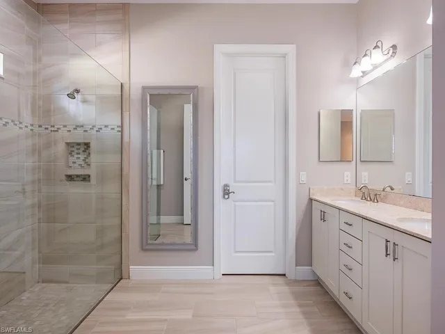 a bathroom with a granite countertop sink mirror and shower