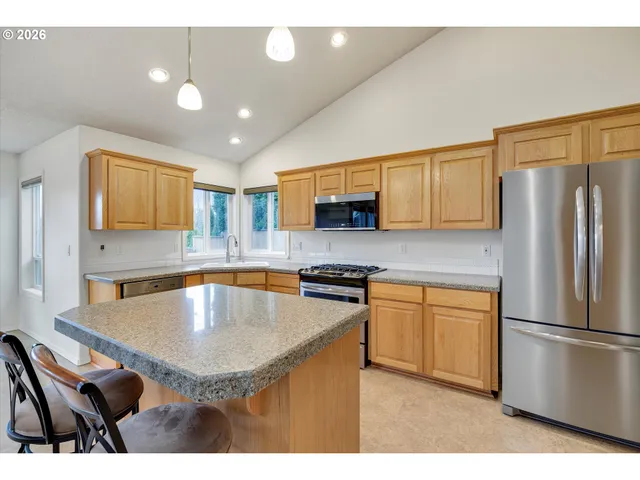 a kitchen with stainless steel appliances granite countertop a sink a stove a microwave a refrigerator a stove and cabinets