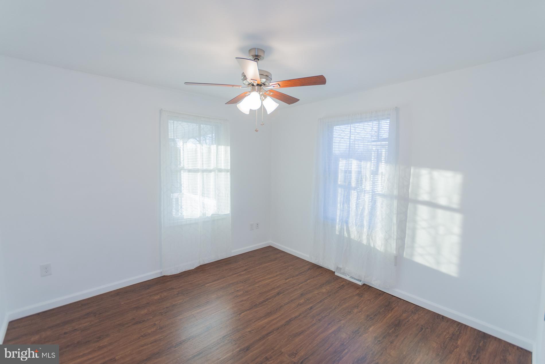 300 West 4th Avenue Ranson, WV 25438 - Photo 16 of 45 an empty room with wooden floor fan and windows