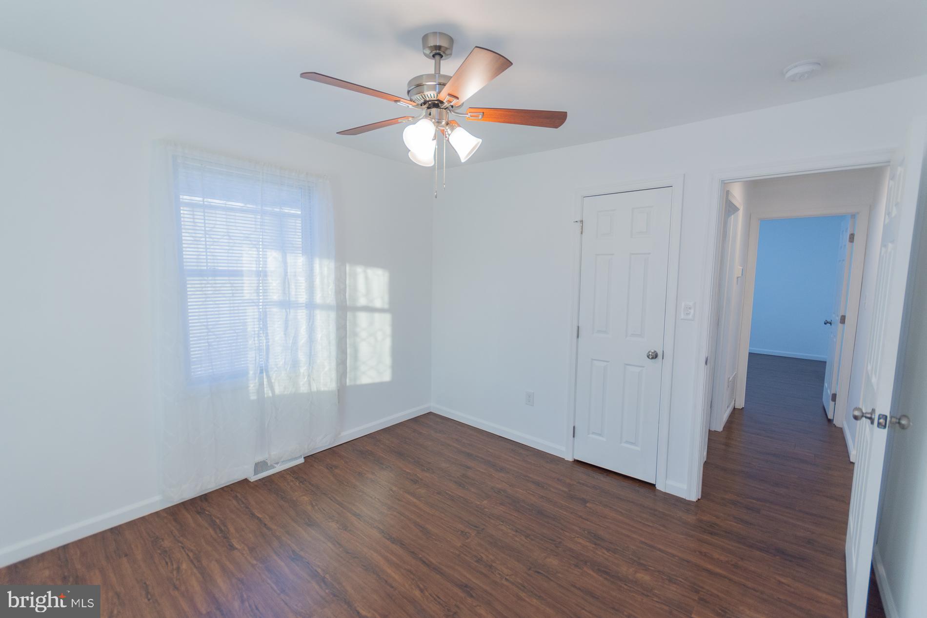 300 West 4th Avenue Ranson, WV 25438 - Photo 17 of 45 an empty room with wooden floor fan and windows