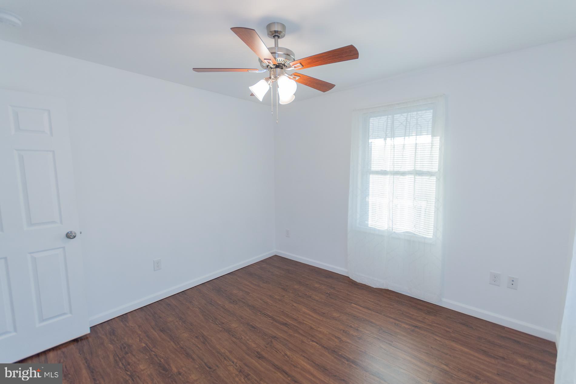 300 West 4th Avenue Ranson, WV 25438 - Photo 19 of 45 an empty room with wooden floor fan and windows