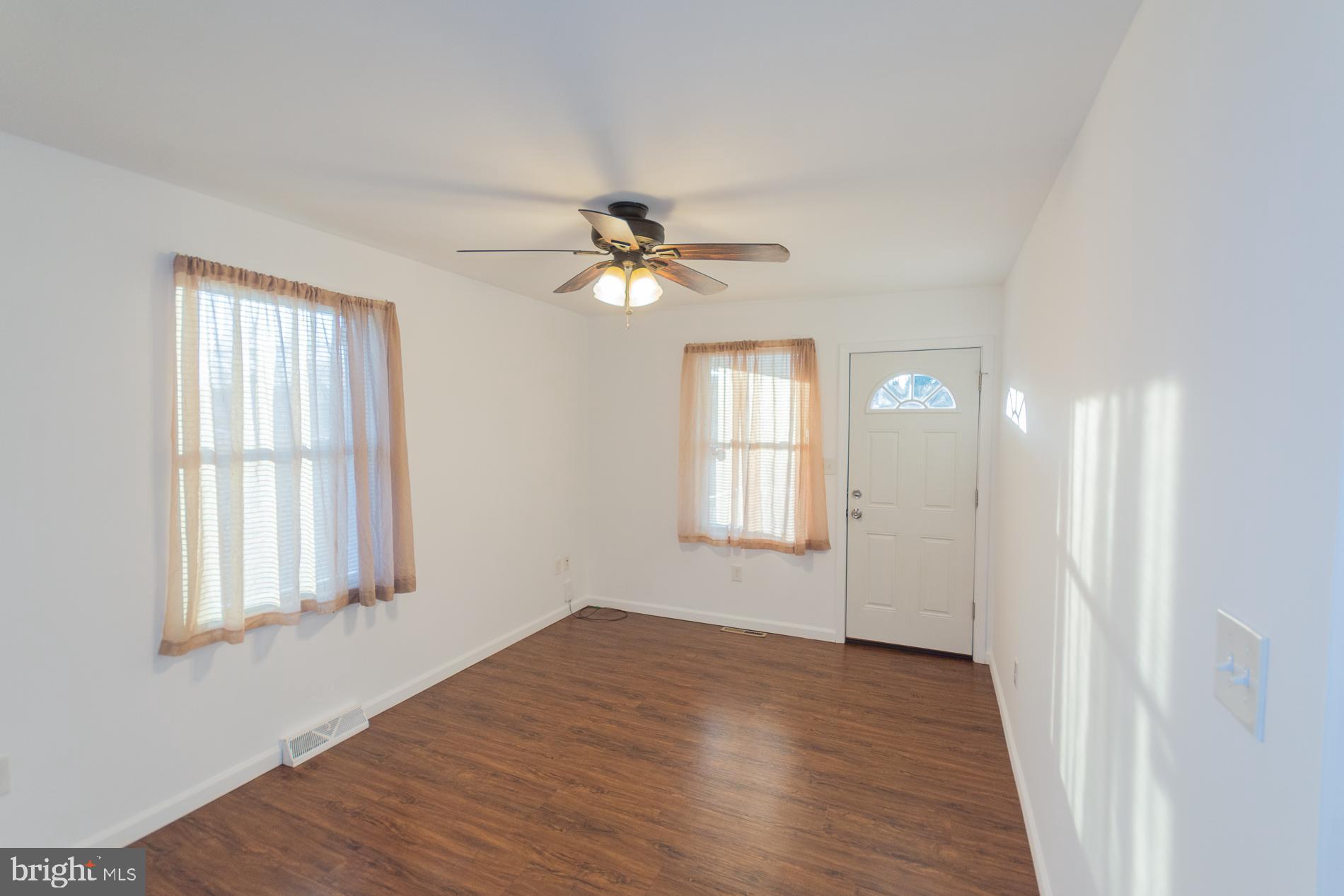 300 West 4th Avenue Ranson, WV 25438 - Photo 5 of 45 an empty room with wooden floor fan and windows
