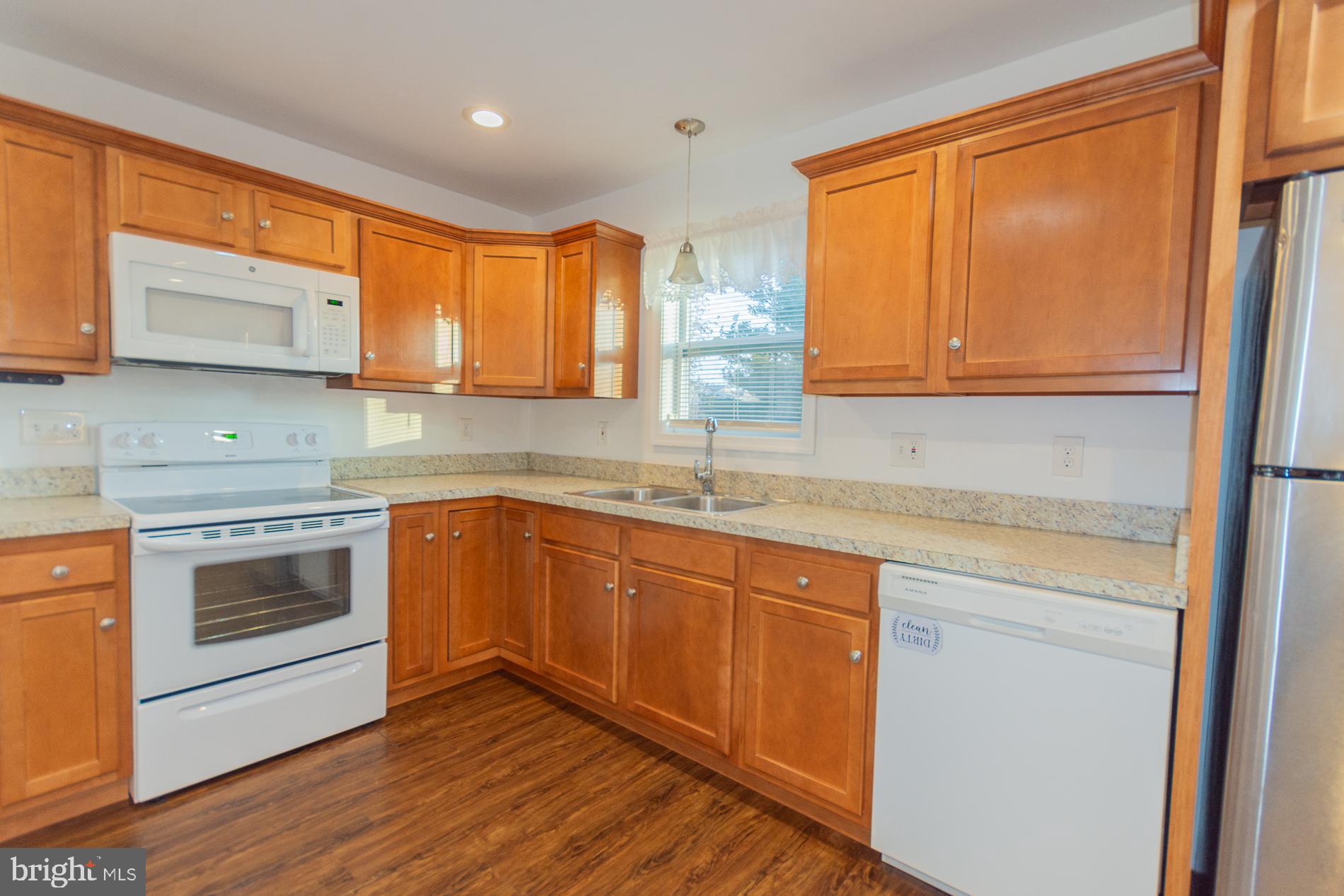 300 West 4th Avenue Ranson, WV 25438 - Photo 10 of 45 a kitchen with stainless steel appliances granite countertop wooden floors a stove a sink and a microwave