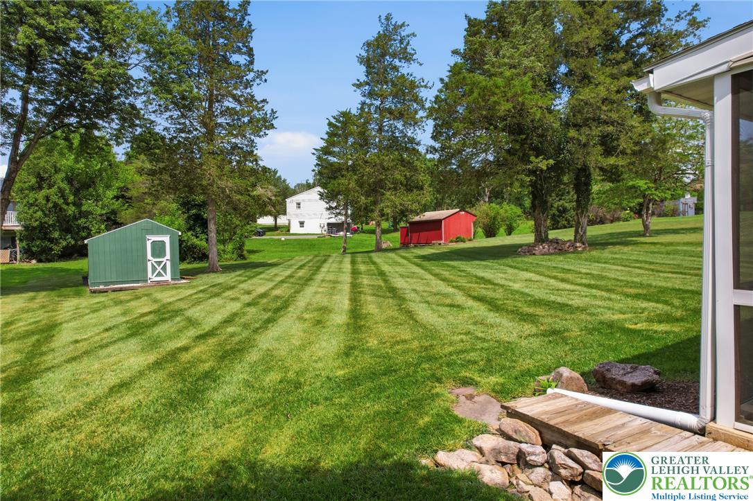1385 Woodmere Road Pottstown, PA 19464 - Photo 42 of 57 A sprawling green lawn with neat stripes features multiple storage sheds and mature trees.