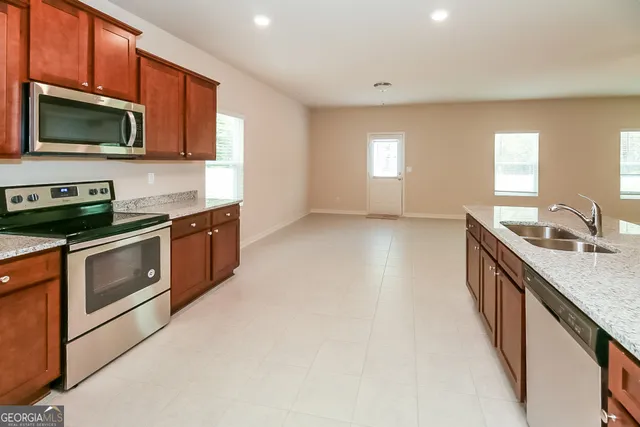 a kitchen with stainless steel appliances granite countertop a stove a sink and a microwave