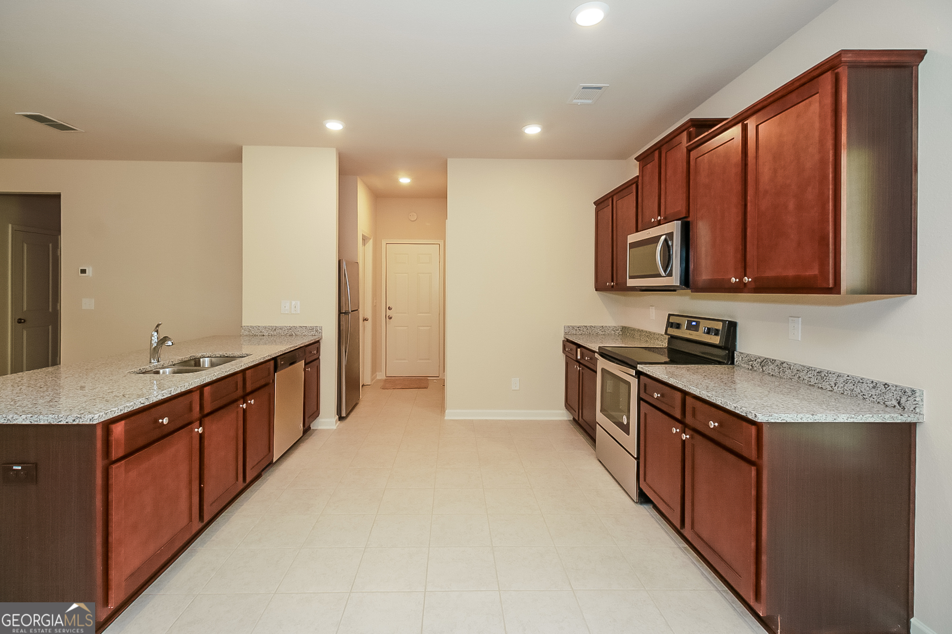 10910 Wheeler Trace Hampton, GA 30228 - Photo 5 of 17 a large kitchen with stainless steel appliances granite countertop a stove a sink and a refrigerator