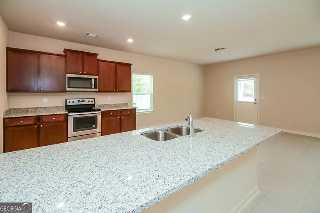 a kitchen with granite countertop a sink and a stove top oven