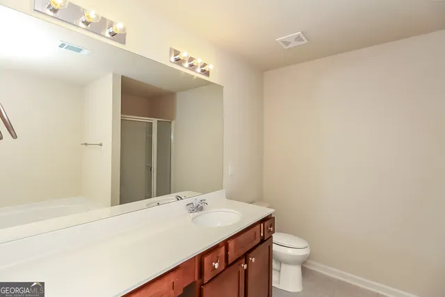 a bathroom with a sink a toilet and mirror