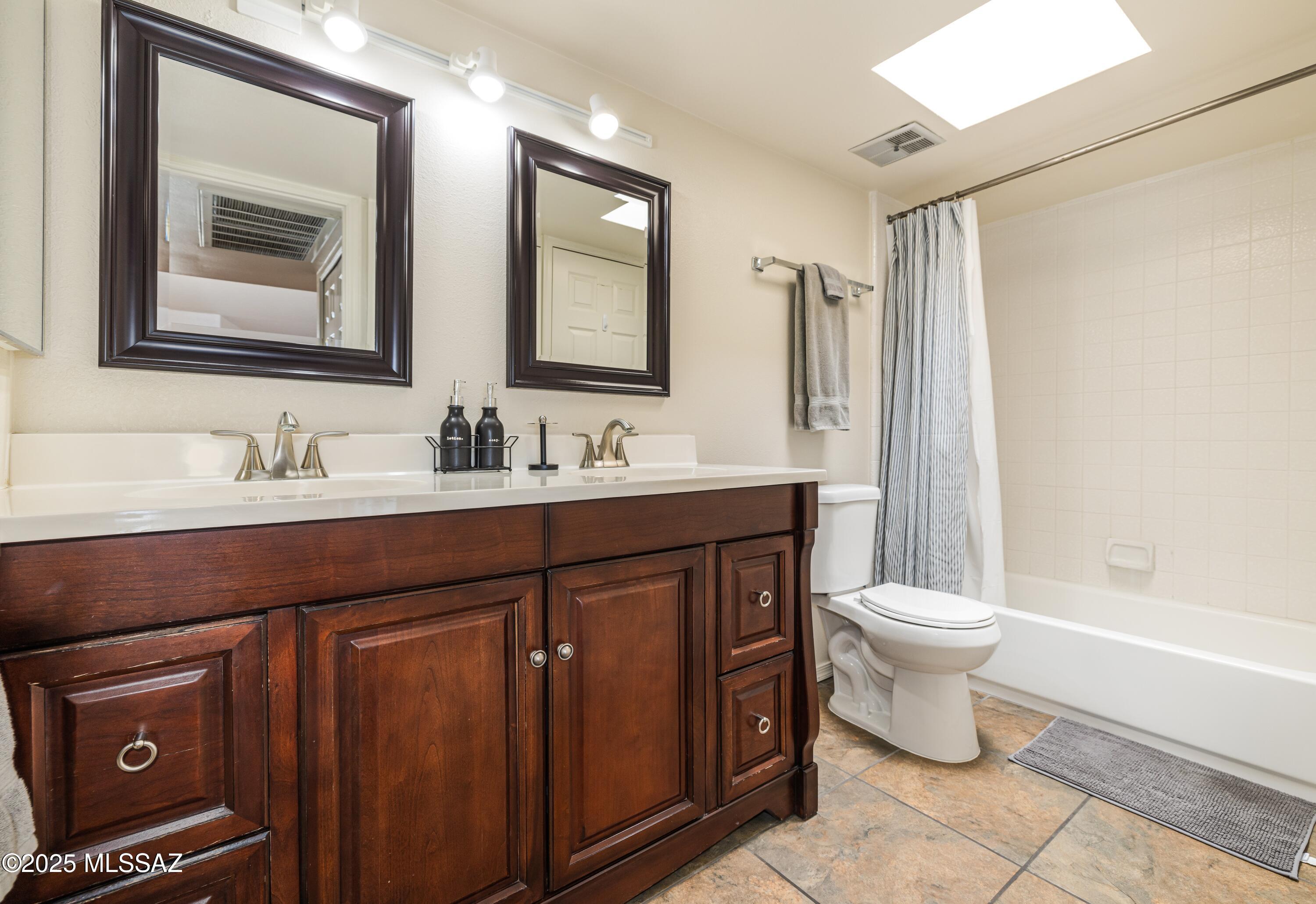 1200 East River Road, Unit G88 Tucson, AZ 85718 - Photo 8 of 13 a bathroom with a double vanity sink a toilet and a mirror