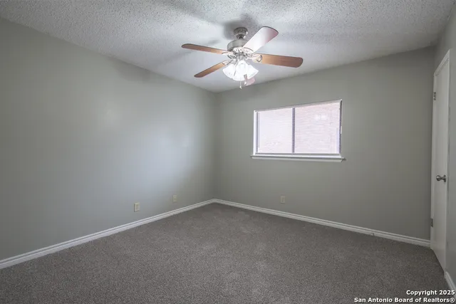 an empty room with a chandelier fan and a chandelier fan