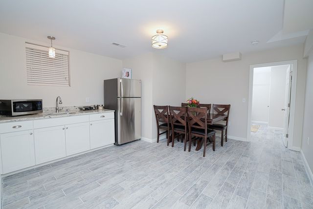 a kitchen with a dining table chairs appliances and cabinets