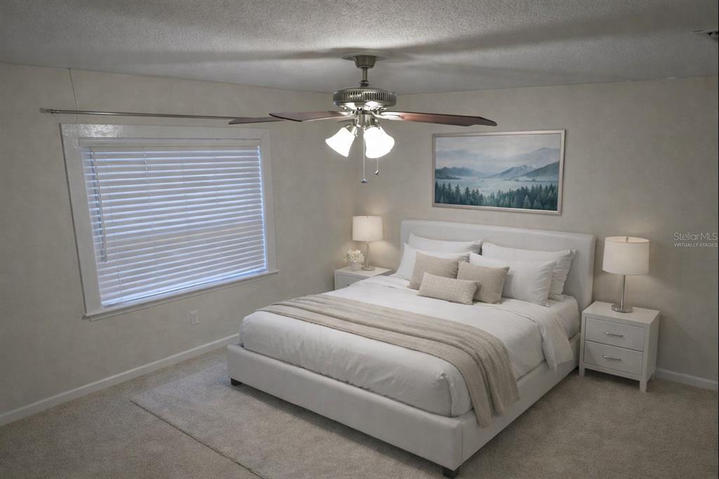 34041 Highland Road Leesburg, FL 34788 - Photo 12 of 33 a bedroom with a bed and a chandelier