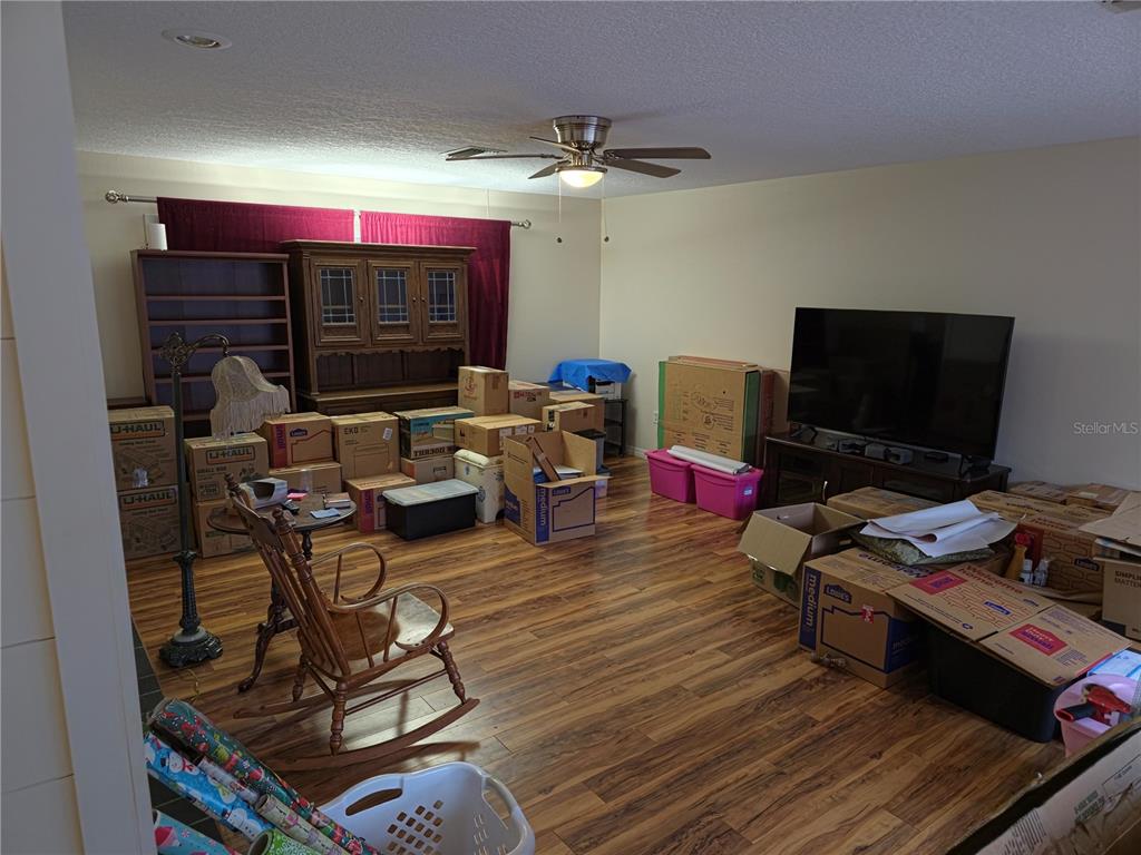 34041 Highland Road Leesburg, FL 34788 - Photo 26 of 33 a living room with furniture and a flat screen tv