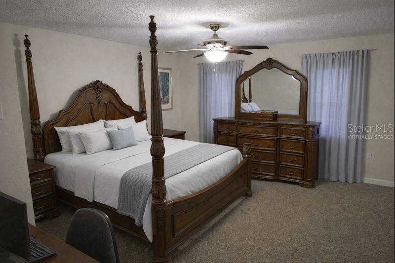 34041 Highland Road Leesburg, FL 34788 - Photo 10 of 33 a bedroom with a bed a dresser and potted plants