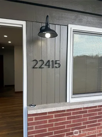 a small white house with a white fence and large trees