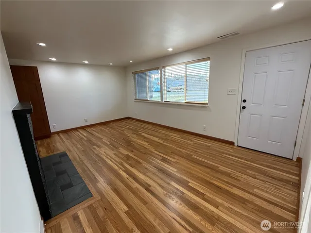 a large kitchen with a sink and wooden floor