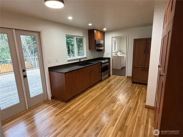 a large kitchen with stainless steel appliances granite countertop a refrigerator and a sink