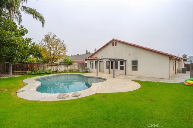 a view of a house with a yard potted plants and large tree