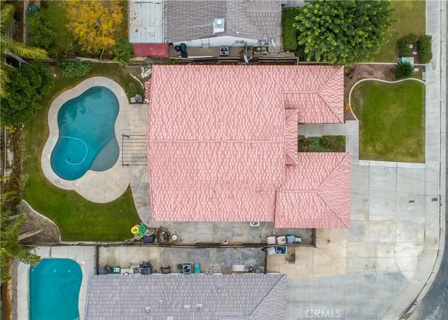 an aerial view of a house with swimming pool and outdoor seating
