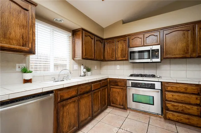 a kitchen with stainless steel appliances granite countertop a sink stove and microwave